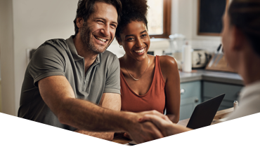 A couple shaking hands with an advisor